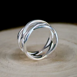 Detailed close-up view of the silver woven interlocking ring showcasing openwork craftsmanship.