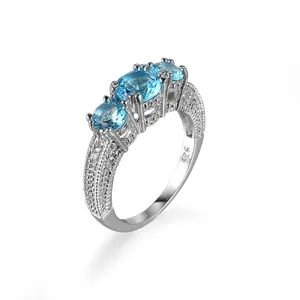 Detailansicht des silbernen Ringes mit funkelnden blauen Zirkoniasteinen verziert.