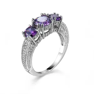 Detaillierte Nahaufnahme des dreisteinigen lila Zirkonia-Rings mit edlem Pavé-Band.