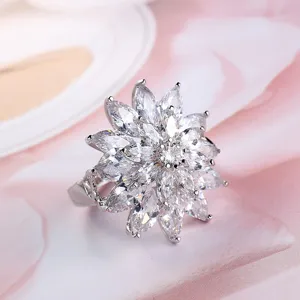 Close-up van een prachtige sprankelende bloemvormige ring bezet met witte markies zirkoniasteentjes.