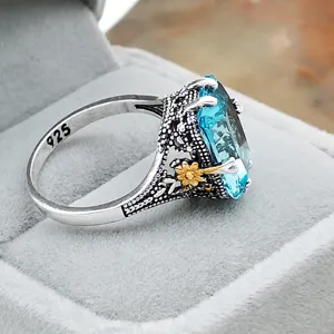 Vintage 925 silver ring featuring a large aqua blue gemstone and delicate golden floral details.