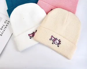 Close-up detail of cute cartoon axolotl embroidered knitted beanie hats in multiple sweet colors.