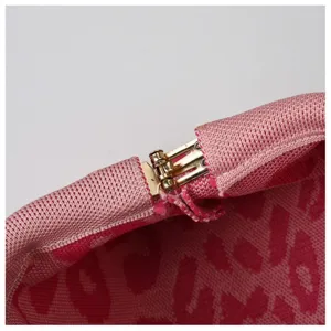 Close-up detail shot of the metal clasp hinge and pink knitted fabric of the cloud bag.