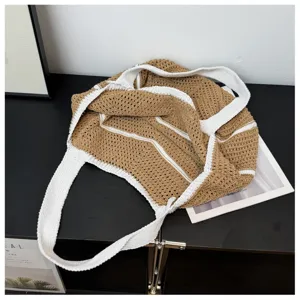 Detailansicht einer lässigen braunen Strick Häkel Schulter Tote Tasche mit kontrastierenden Trägern.