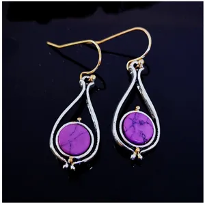 Elegant two-tone drop earrings featuring stunning purple turquoise stones and delicate metal frames.