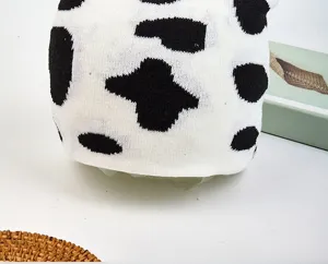 Dettaglio berretto in maglia, trama stampa mucca bianco e nero, moda autunno inverno.