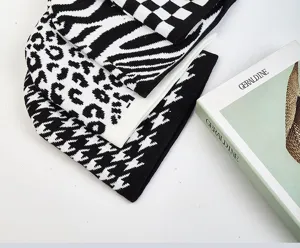 Set di berretti in maglia nero e bianco con motivi zebra, leopardo e pied de poule.