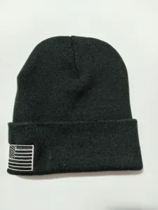 Nahaufnahme Detail einer schwarzen Strickmütze mit US-Flaggen-Stickerei am Bündchen.