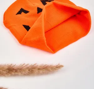 Close-up detail of orange Halloween pumpkin knit beanie hat, cozy winter accessory.