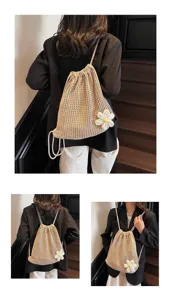 Détail d'un sac à dos cordon tricoté, style plage et loisir, avec une jolie fleur décorative.