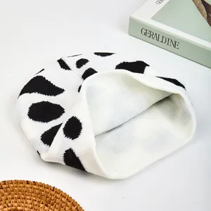 Berretto in maglia con stampa mucca bianco e nero vista principale, cappello invernale casual.