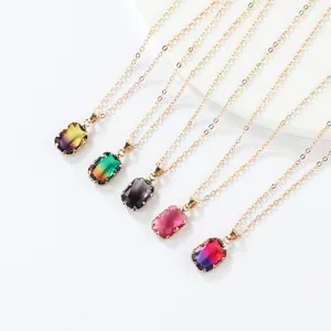 Close-up detail of multi-color gradient gemstone pendant necklaces with gold chains.