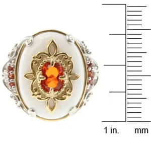 Primer plano de anillo barroco de oro y plata con gema naranja y nácar blanco brillante.