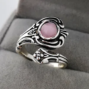 Anello aperto in argento vintage con pietra di cristallo rosa, dettaglio floreale intagliato.