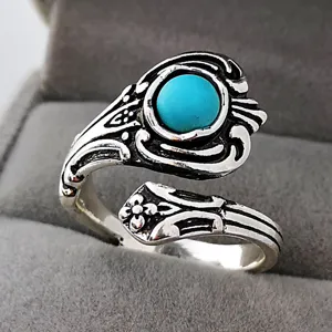Anello in argento regolabile vintage con gemma turchese rotonda e dettagli floreali intagliati.