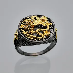 Primer plano detallado del anillo de dragón negro y oro con detalles complejos y piedra brillante.