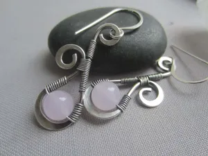 Detail des boucles d'oreilles en cristal rose fil de fer enroulé style vintage artisanal.