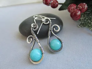Boucles d'oreilles en argent filaire artisanales avec perles de turquoise vue de détail.