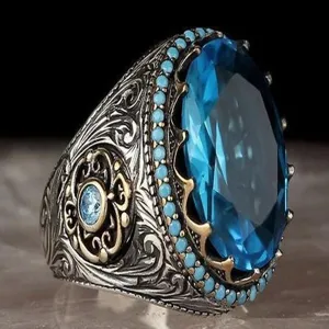 Anello vintage da uomo con grande pietra preziosa blu e dettagliati intagli in filigrana.