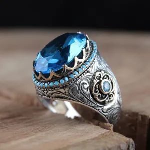 Primo piano anello uomo argento vintage con grande gemma blu e perline turchesi dettagli.