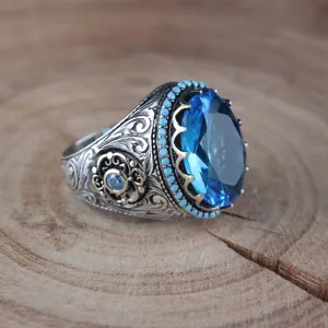 Dettaglio anello da uomo in argento sterling vintage con grande gemma blu e decorazione fine.
