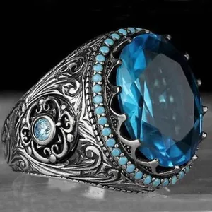 Primo piano dell'anello vintage da uomo in argento con pietra blu e dettagli intagliati.