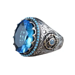 Anello da uomo vintage con grande gemma blu, fascia in argento decorata e incisione floreale.