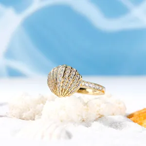 Anello a conchiglia dorato con strass scintillanti, dettaglio di gioiello stile oceano.