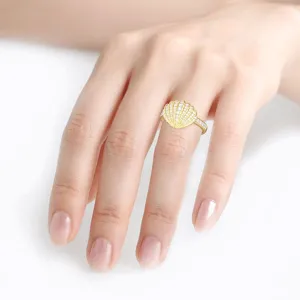 Primo piano dettagliato di un anello a conchiglia dorato con diamanti brillanti sulla mano.