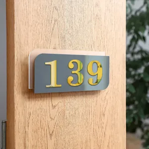 Detail van acryl huisnummer, gouden spiegel cijfers 139 op houten deur gemonteerd.