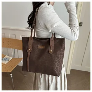 Detail view of the stylish brown leopard print tote bag with brown leather handles and classic design.