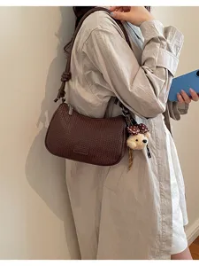 Stylish brown woven shoulder bag for women, chic hobo underarm pillow bag with cute charm.