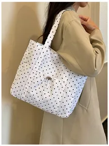 Vue détaillée du joli sac cabas en toile à pois, avec une poche avant pratique à cordon.