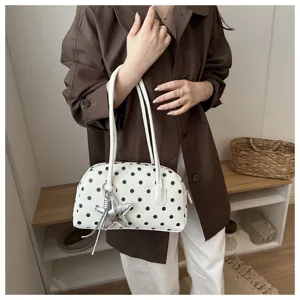 Detail view of the white polka dot bowling shoulder bag with chic silver star charm.