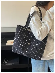Vue détaillée du sac cabas en toile à pois noirs et blancs de style coréen porté par le modèle.