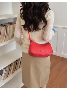 Red woven underarm shoulder bag for women, stylish pillow bag with adjustable strap.