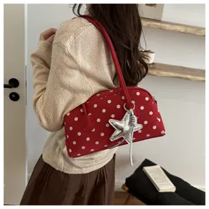 Red polka dot shoulder bowling bag with star charm, stylish daily commuting handbag detail view.