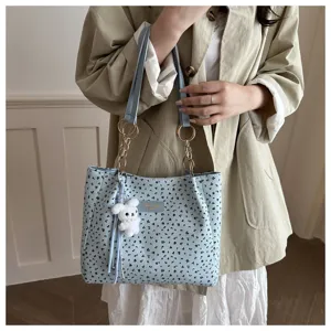 Detailansicht der hellblauen floralen Schultertasche mit Plüschhase und Kettendetails.