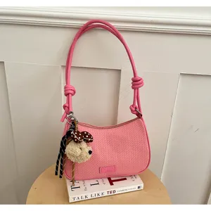 Pink woven shoulder bag for women, stylish hobo underarm handbag with cute plush bear charm.