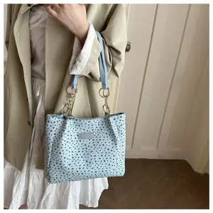 Schickes Blumen-Schultertaschen-Detail mit zartem Muster und eleganter Kettengriff.