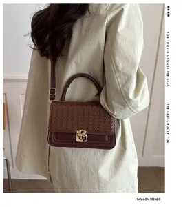 Elegante Umhängetasche für Damen aus geflochtenem Leder mit Metallschloss und breitem Gurt.