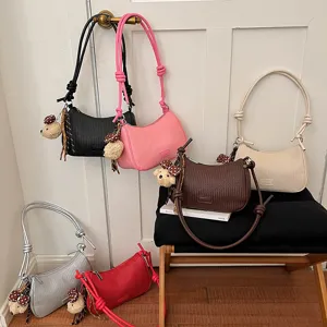 Woven underarm shoulder bag for women, stylish PU leather hobo handbag with cute bear charm.