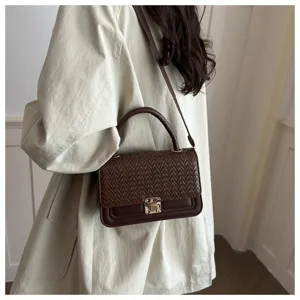 Braune geflochtene Ledertasche Detailaufnahme, stilvolle Umhängetasche mit Metallasche.