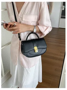 Vista dettagliata della borsa nera con chiusura metallica e manico per uno stile elegante.