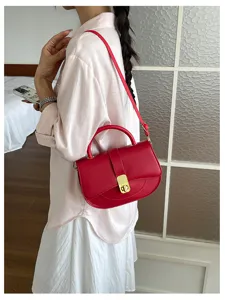 Vista dettagliata dell'elegante borsa a tracolla rossa con chiusura metallica dal modello.