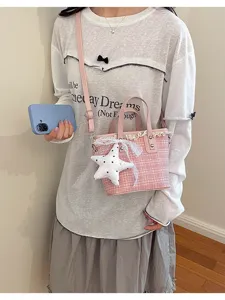 Detailed view of the pink tweed bucket bag with cute lace trim and star pendant.
