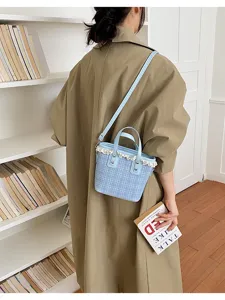 Detail view of stylish blue plaid bucket bag with lace trim, casual shoulder handbag.