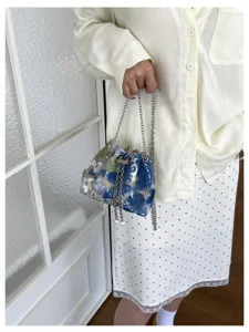Detailansicht der eleganten Damen Pailletten Schultertasche mit Blumenmuster und Kettenriemen.