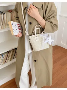 Detail view of beige plaid bucket bag with lace trim and star plush charm pendant.