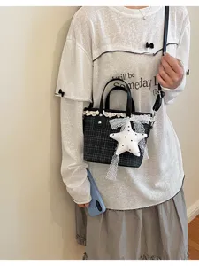 Close-up of a stylish plaid bucket bag with cute lace trim and star pendant for daily wear.